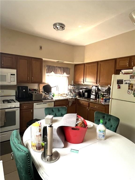 kitchen featuring dark countertops and white appliances