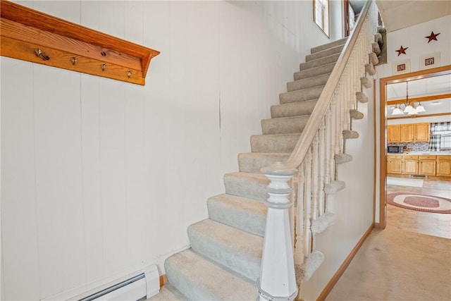 stairs with baseboard heating, carpet, and baseboards