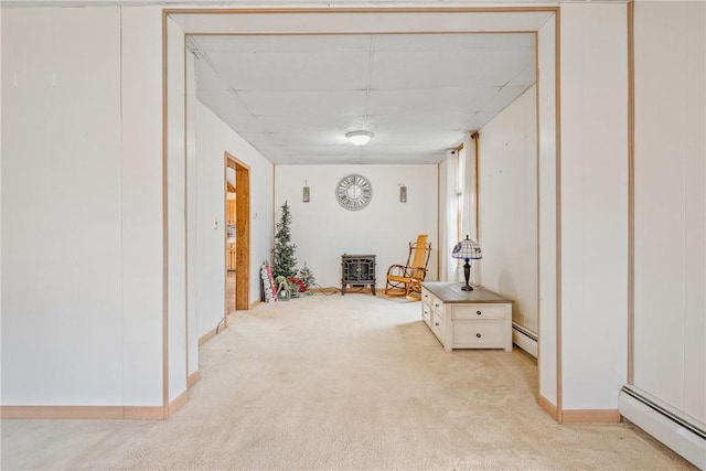 hall featuring light carpet, baseboard heating, and baseboards