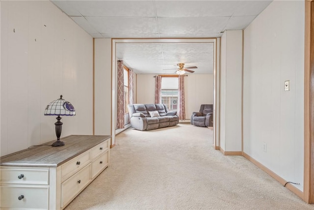 hall featuring baseboards and light carpet