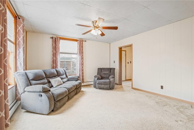 living room with baseboard heating, baseboards, ceiling fan, and carpet floors