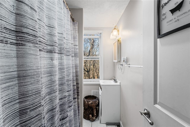 full bathroom featuring curtained shower, a textured ceiling, and vanity