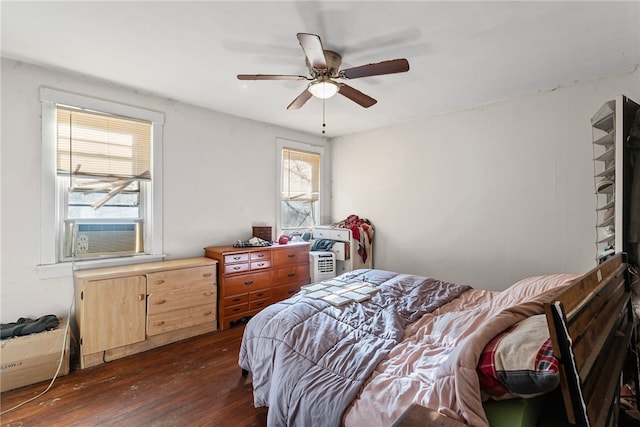 bedroom with cooling unit, ceiling fan, and dark wood-style flooring