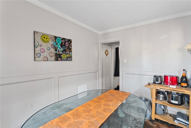 dining space featuring visible vents, crown molding, and a decorative wall