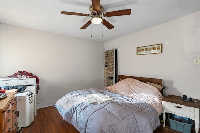 bedroom featuring a ceiling fan, baseboards, and wood-type flooring