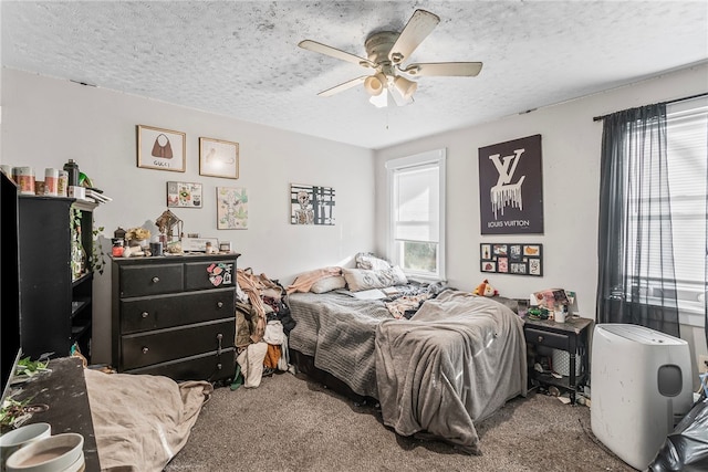 carpeted bedroom featuring a textured ceiling and ceiling fan