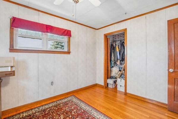 unfurnished room with crown molding, a ceiling fan, and wood finished floors