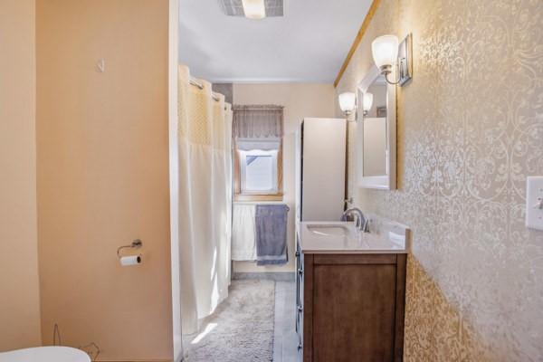 full bath featuring vanity, visible vents, wallpapered walls, curtained shower, and toilet