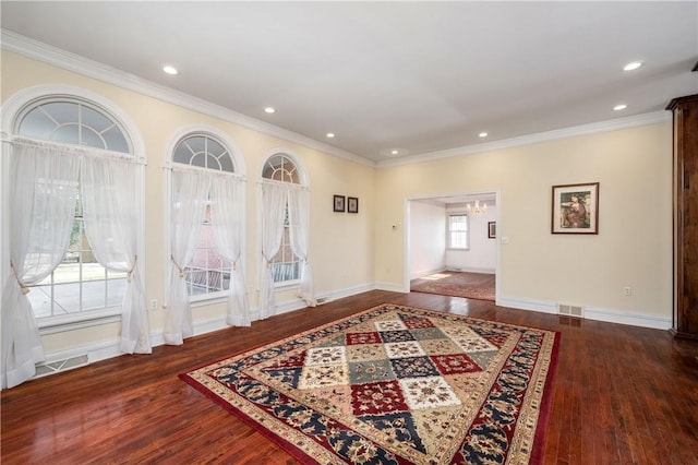 interior space featuring visible vents, crown molding, baseboards, an inviting chandelier, and wood finished floors