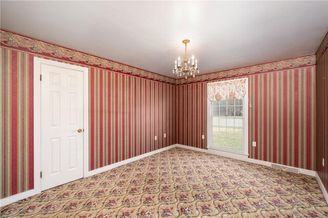 carpeted empty room with visible vents, baseboards, a notable chandelier, and wallpapered walls