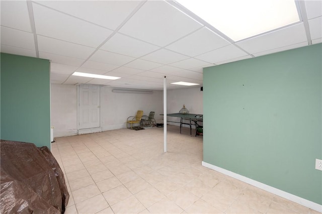 finished basement with a drop ceiling and baseboards