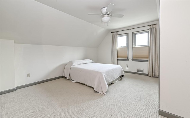 bedroom featuring visible vents, baseboards, carpet, lofted ceiling, and a ceiling fan