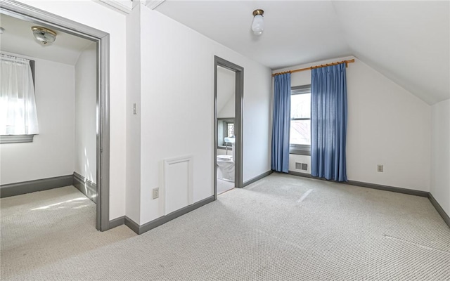 interior space with baseboards, carpet, and vaulted ceiling