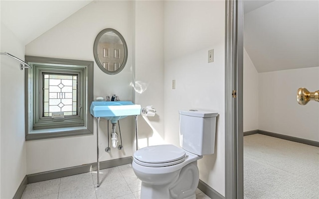 bathroom featuring vaulted ceiling, toilet, and baseboards