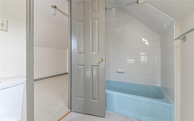 bathroom with toilet, bathing tub / shower combination, and vaulted ceiling