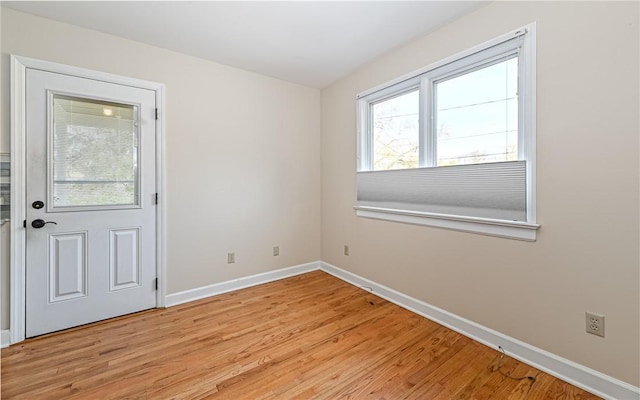 unfurnished room featuring baseboards and light wood finished floors