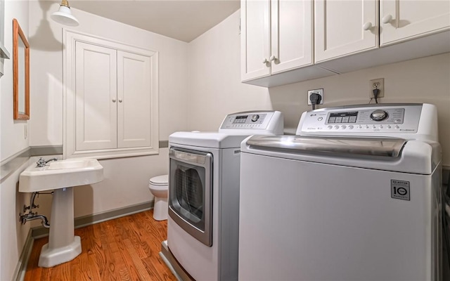 laundry room featuring laundry area, washing machine and dryer, and light wood finished floors