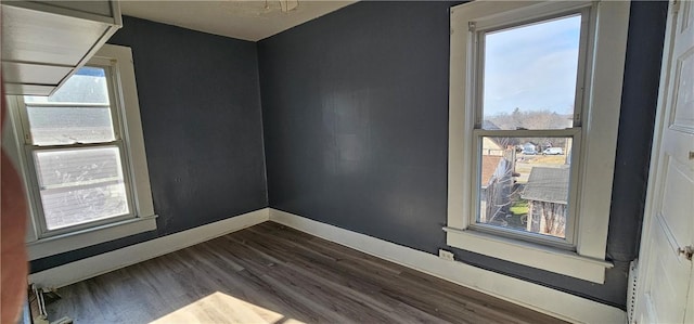 unfurnished room featuring dark wood-style floors and baseboards