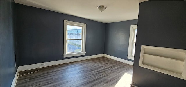 empty room featuring baseboards and wood finished floors