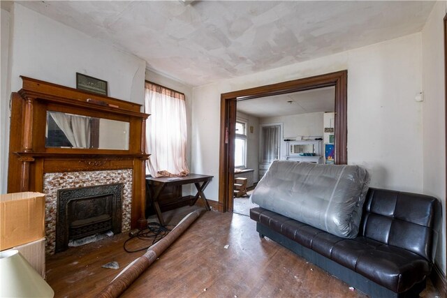 living room with baseboards, wood finished floors, and a tile fireplace