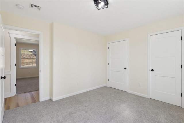 unfurnished bedroom with visible vents, carpet flooring, and baseboards