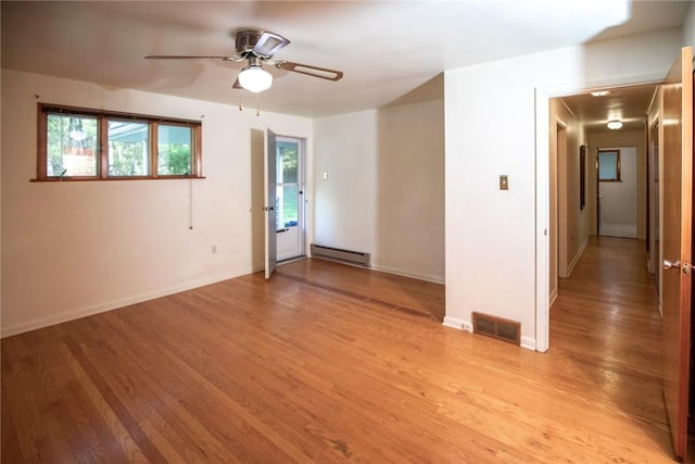 empty room featuring a baseboard radiator, light wood-style floors, ceiling fan, and baseboards