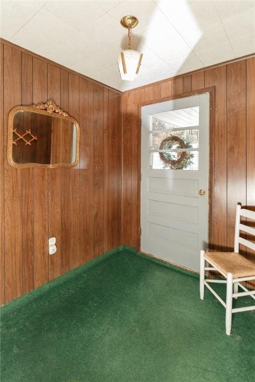 carpeted foyer entrance with wood walls