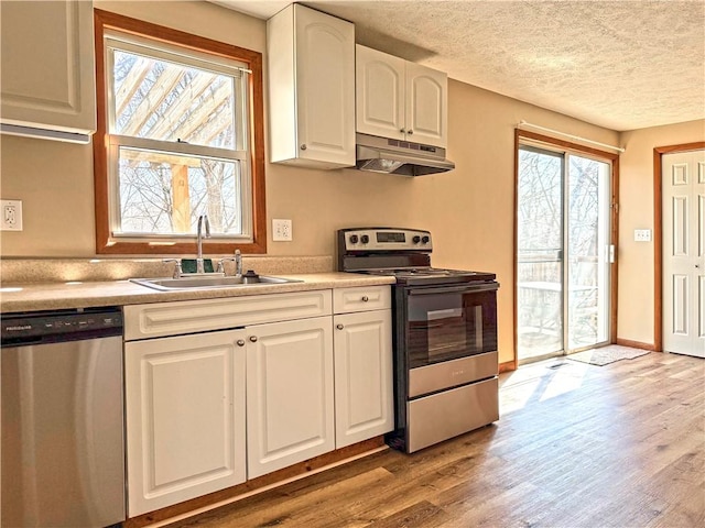478 Spang Ave, Leechburg Boro, PA 15656 - kitchen featuring under cabinet range hood, wood finished floors, white cabinets, stainless steel appliances, and a sink