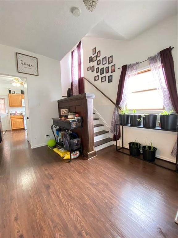 living area with a wealth of natural light, stairway, and wood finished floors