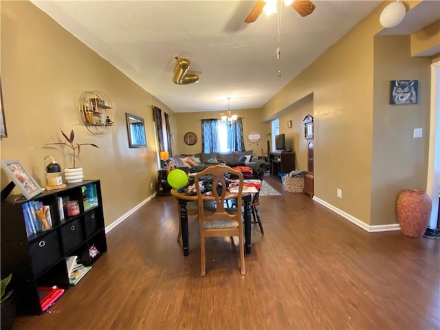 dining room featuring baseboards, wood finished floors, and ceiling fan with notable chandelier