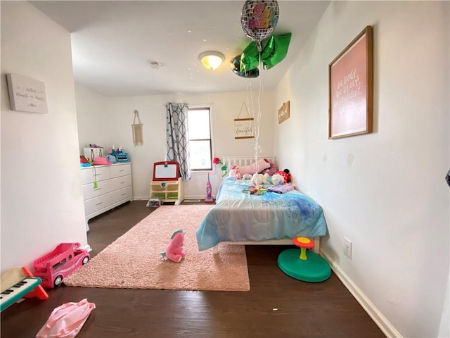 bedroom with baseboards and wood finished floors