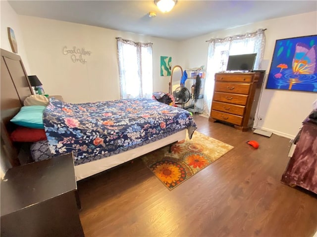 bedroom with baseboards and wood finished floors