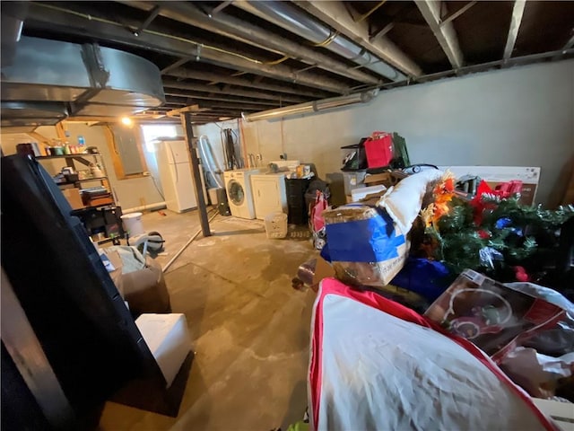 unfinished basement featuring freestanding refrigerator and washing machine and dryer