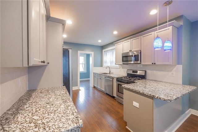3361 Portola Ave, Observatory Hill, PA 15214 - kitchen featuring stainless steel appliances, a peninsula, dark wood finished floors, decorative backsplash, and recessed lighting