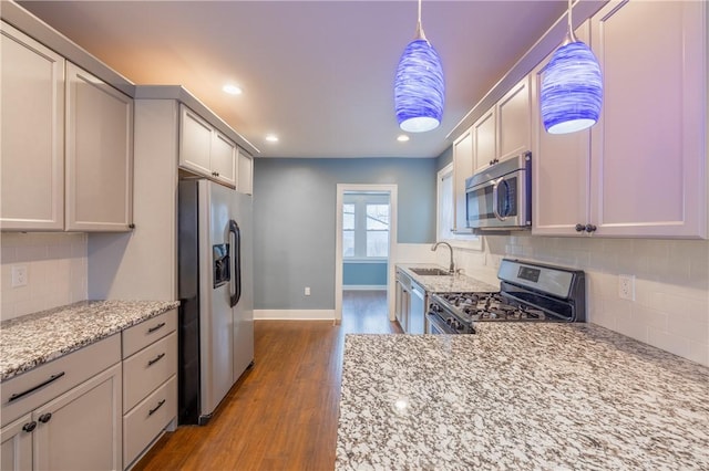 3361 Portola Ave, Observatory Hill, PA 15214 - kitchen featuring appliances with stainless steel finishes, dark wood finished floors, tasteful backsplash, light stone counters, and recessed lighting