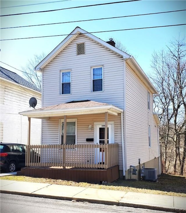 view of front of house featuring central air condition unit, a porch, and a chimney