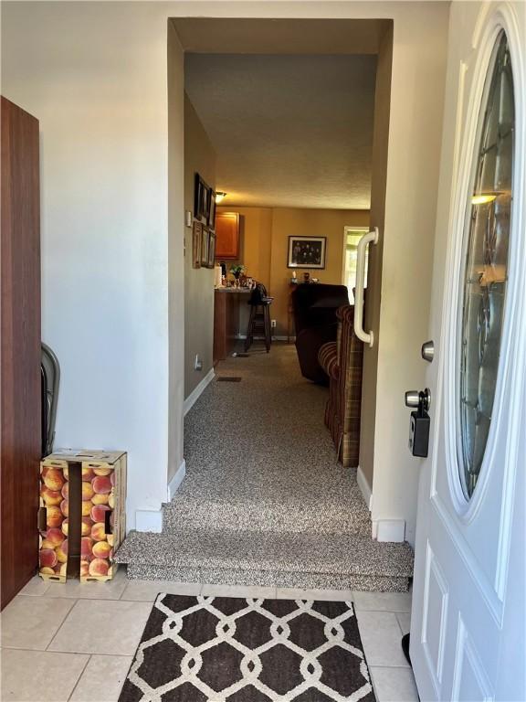 310 Church St, Harrisville Boro, PA 16038 - foyer entrance featuring light tile patterned flooring, baseboards, and light carpet
