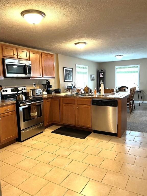 310 Church St, Harrisville Boro, PA 16038 - kitchen with appliances with stainless steel finishes, a peninsula, dark countertops, plenty of natural light, and a textured ceiling