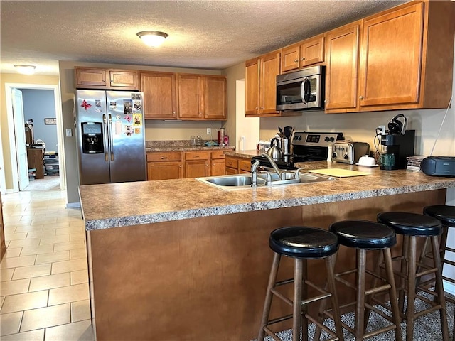 310 Church St, Harrisville Boro, PA 16038 - kitchen with stainless steel appliances, brown cabinets, a peninsula, a sink, and a textured ceiling