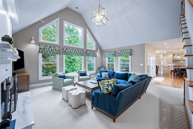 living area with stairs, a fireplace, and high vaulted ceiling