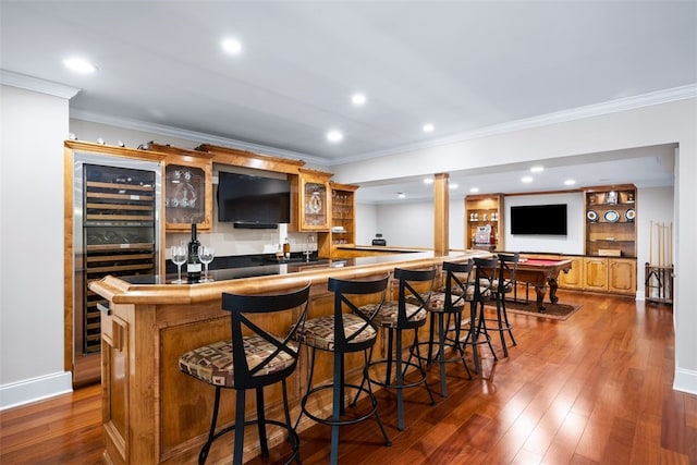 bar with wet bar, crown molding, beverage cooler, and dark wood-style flooring