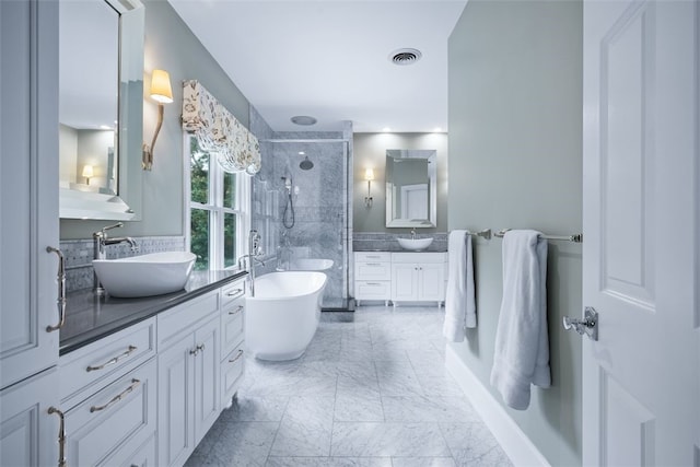 bathroom featuring visible vents, marble finish floor, a tile shower, a soaking tub, and vanity