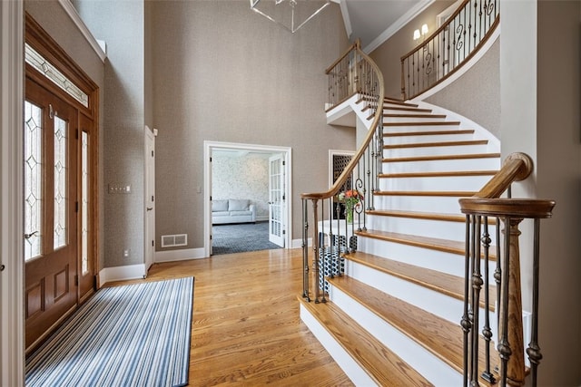 foyer with visible vents, a healthy amount of sunlight, wood finished floors, and stairway