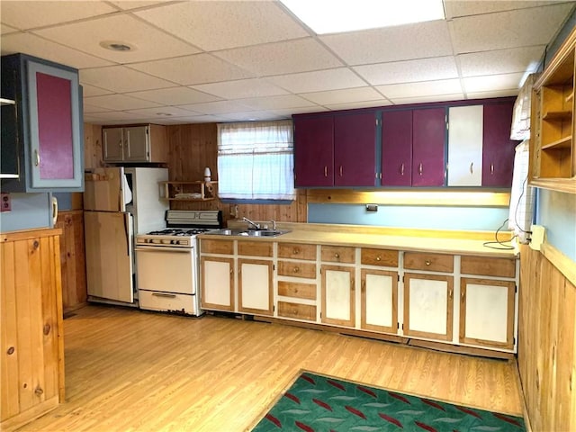 406 Peach St, City Of But Ne, PA 16001 - kitchen featuring white appliances, light wood finished floors, a sink, a paneled ceiling, and wood walls