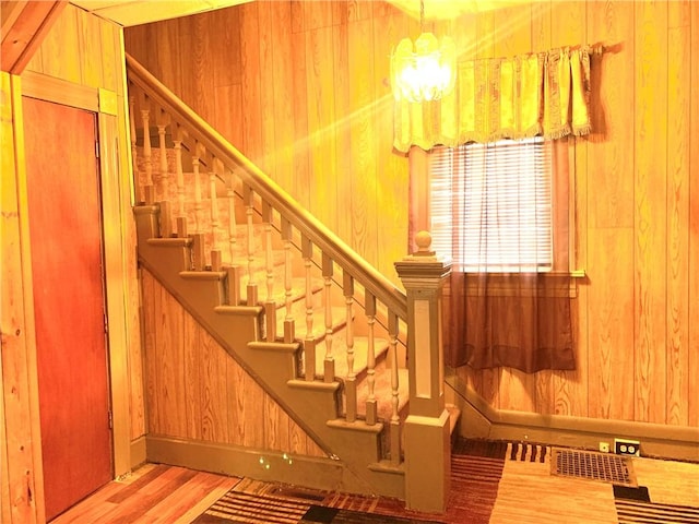 406 Peach St, City Of But Ne, PA 16001 - staircase with wooden walls, a chandelier, and wood finished floors