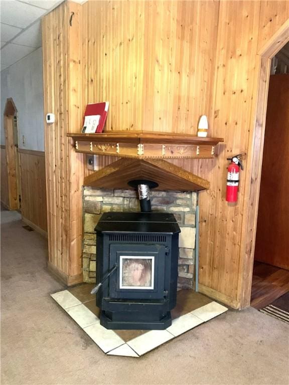 406 Peach St, City Of But Ne, PA 16001 - detailed view of a fire extinguisher, a wood stove, carpet floors, wooden walls, and baseboards