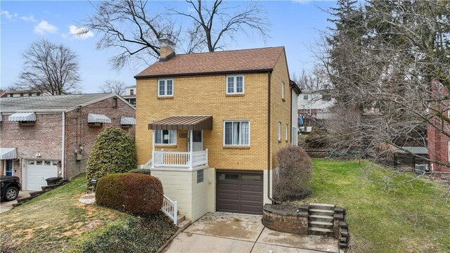 view of front of home featuring brick siding, a front lawn, a chimney, a garage, and driveway