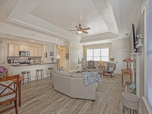 232 Adams Pointe Blvd Unit 6, Adams Twp, PA 16046 - living room featuring a tray ceiling, light wood-style flooring, and ceiling fan
