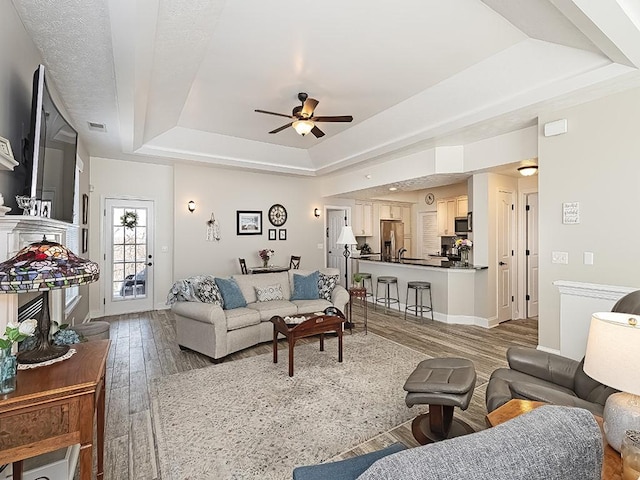 232 Adams Pointe Blvd Unit 6, Adams Twp, PA 16046 - living room featuring a tray ceiling, wood finished floors, ceiling fan, and baseboards