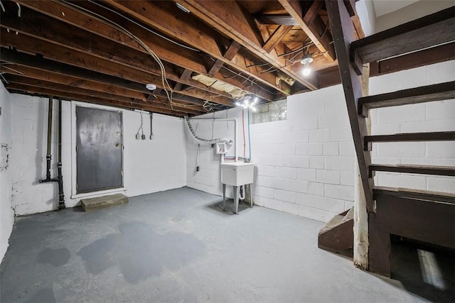 unfinished below grade area featuring a sink and concrete block wall